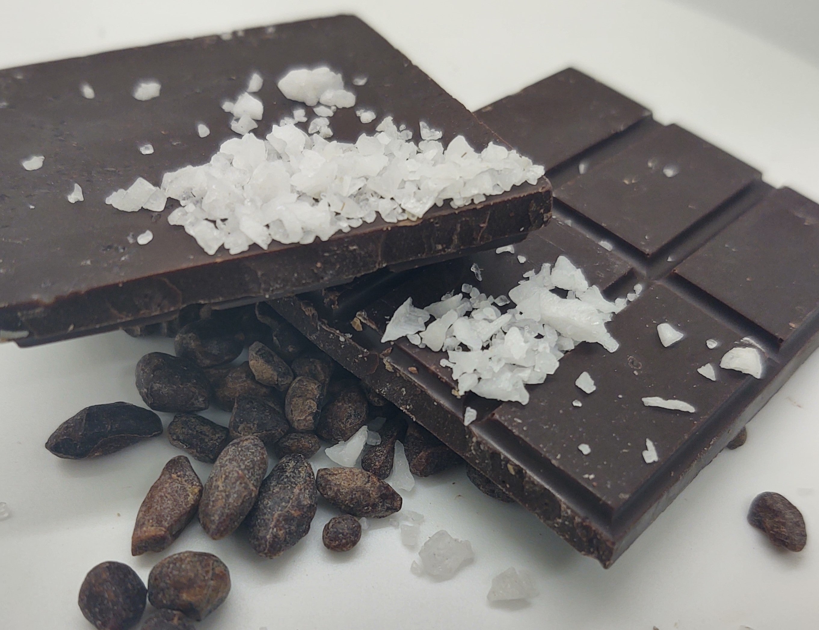Pictured: Solid dark chocolate bar mounted by raw sea salt and cocoa nibs