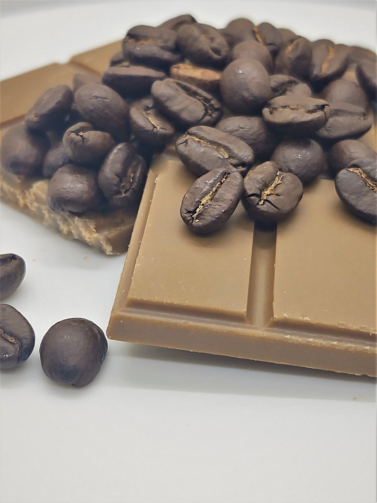 Pictured: a solid mocha flavored chocolate bar mounted by whole, roasted coffee beans