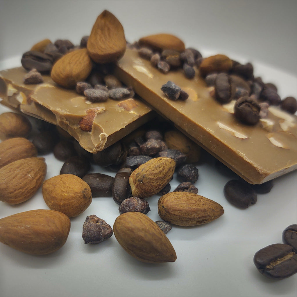 Pictured: a solid mocha flavored chocolate bar mounted by whole, roasted coffee beans and whole almonds